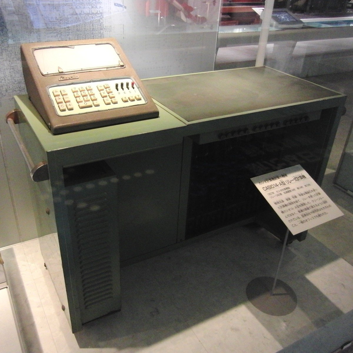 La calculadora Casio 14-A de 1957, del tamaño de una mesa de oficina, dentro de una vitrina del Museo Nacional de Naturaleza y Ciencia de Tokio. Encima, una consola marrón con teclado y la marca Casio.